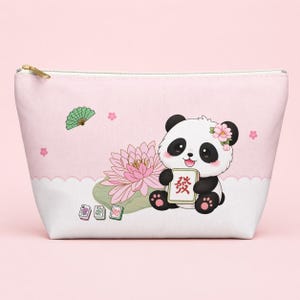 Op de afbeelding: Een lichtroze en wit etui met rits voorzien van een cartoonpanda die een mahjongtegel met het rode karakter Fa vasthoudt. Het ontwerp bevat een roze lotusbloem, een groene waaier en drie extra mahjongtegels op een witte ondergrond.