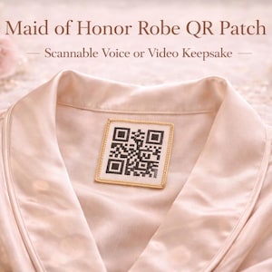 May include: A light peach-colored satin robe with a QR code patch on the collar. The patch is square with a gold border and a black and white QR code. Text above the robe reads "Maid of Honor Robe QR Patch".