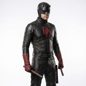 May include: A black leather costume featuring a fitted jacket with a red DD emblem on the chest, matching trousers, and a full-face mask with small horns. The outfit includes red hand wraps and two red batons held in the hands and a holster.