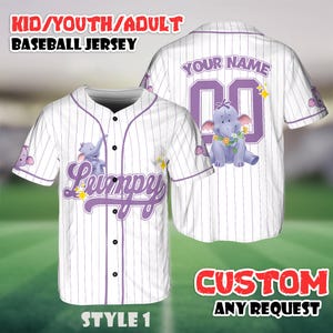 May include: White baseball jersey with purple pinstripes, featuring a cartoon elephant graphic. The front displays the name "Lumpy" in purple script, and the back has space for a custom name and number. The jersey is labeled "Style 1".