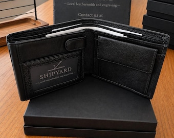 Könnte beinhalten: Ein schwarzes Leder-Portemonnaie mit zwei Fächern und einem Sichtfenster, das den Text SHIPYARD Local leathersmith and engraving zeigt. Das geöffnete Portemonnaie mit Kartenfächern und Münzfach liegt auf einer schwarzen Schachtel mit Schiefertafel.