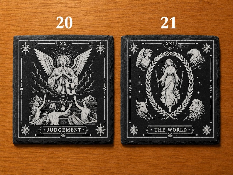 May include: Two square black slate coasters featuring white engraved tarot card designs. The left coaster shows Judgement with an angel and figures rising from coffins. The right coaster shows The World with a central figure, laurel wreath, and four animal heads.