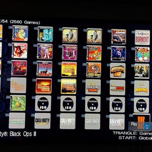 May include: A screen displaying a selection of PlayStation games. The image shows game covers with titles like "Call of Duty: Black Ops III", "Burnout", and "Deer Hunter". The screen displays "Page 7/54 (2560 Games)".