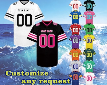 May include: A collection of short-sleeved sports jerseys featuring a V-neck collar, the text "TEAM NAME" on the chest, and the number "00" below. The jerseys are displayed in various color combinations, including white, black, blue, pink, green, and yellow.