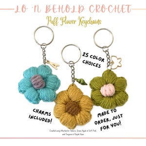 May include: Three handmade crochet puff flower keychains in teal, mustard, and olive green. Each flower has a different colored center and is attached to a silver keyring. The text says "25 COLOR CHOICES" and "CHARMS INCLUDED!"