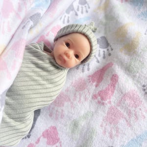 May include: A set of three ceramic mugs with a speckled, matte finish. The mugs are in shades of cream, light gray, and dark gray. Each mug has a simple, minimalist design, perfect for coffee or tea.