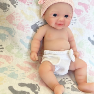 May include: A white ceramic mug with a black handle and the text "But First, Coffee" in a bold, black font. The mug is set against a neutral background, highlighting its simple design.