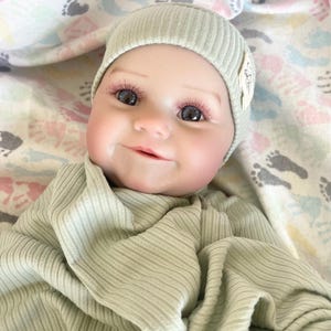 May include: A handmade wooden sign with the text "Welcome" in a playful font. The sign is painted white with black lettering and features a small, decorative heart. It's designed for indoor or outdoor use.