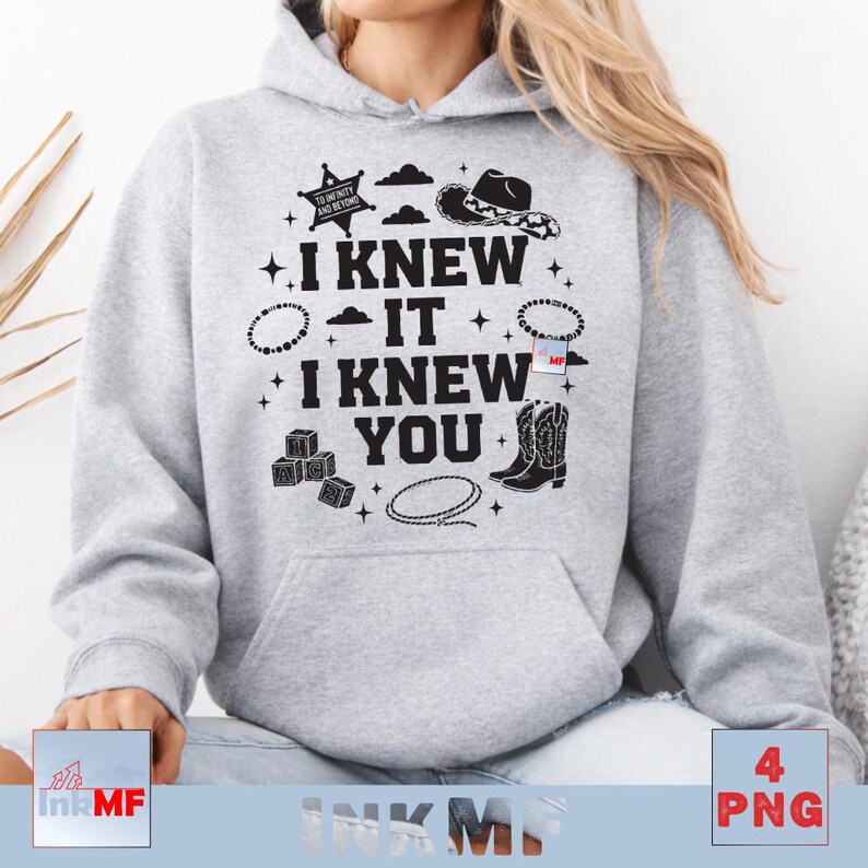 May include: A light gray hooded sweatshirt featuring black graphic text that reads I KNEW IT I KNEW YOU. The design includes illustrations of a sheriff star, a cowboy hat, beaded bracelets, alphabet blocks, a lasso, and cowboy boots.