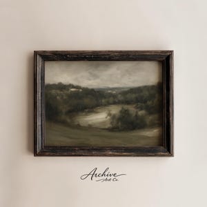 May include: An antique landscape painting in a dark, distressed wooden frame. The artwork depicts a serene, muted-color scene of a valley with trees and a body of water under a cloudy sky. The words "Archive Art Co." are in the bottom right corner.