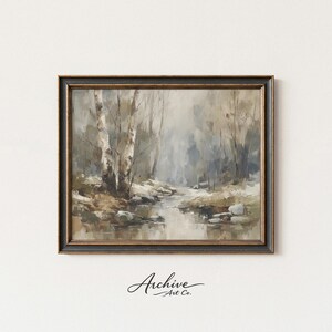 Puede incluir: Pintura de paisaje enmarcada que representa una serena escena de bosque con un arroyo. La obra de arte presenta tonos apagados de gris, marrón y beige, con abedules y una atmósfera brumosa. El marco es oscuro con detalles dorados. El texto "Archive Art Co." está en la esquina inferior.