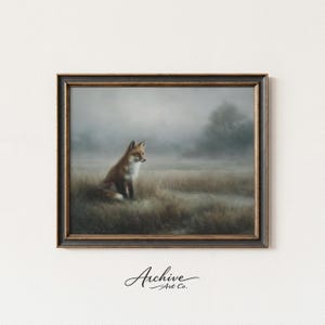 May include: Framed art print featuring a fox in a field. The artwork depicts a red fox sitting in a field of tall grass, with a misty background. The frame is dark brown with gold accents. The print is from Archive Art Co.