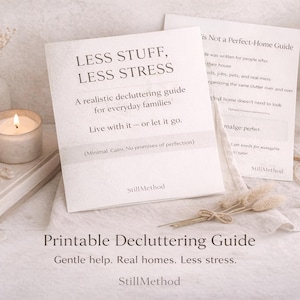 May include: A soft, neutral-toned image featuring a lit candle, a small vase with dried flowers, and a printed guide titled "LESS STUFF, LESS STRESS." The guide promises a realistic decluttering approach for families. Additional text reads "Printable Decluttering Guide" and "Gentle help. Real homes. Less stress."