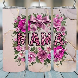 May include: A set of three stainless steel tumblers with lids and straws. Each tumbler features the word "MAMA" in a pink leopard print design, surrounded by pink and white roses, green leaves, and a pink bow. The background has a marble effect.