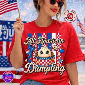 Könnte beinhalten: Rotes T-Shirt mit dem Schriftzug "All American Dumpling" in dekorativer Schrift. Die Grafik zeigt einen Cartoon-Knödel, einen Eis am Stiel, ein Smiley und ein Herz, alles in patriotischen Farben.