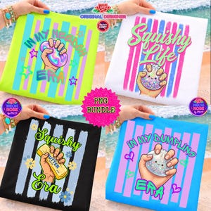 May include: Four t-shirts with vibrant graphic designs. One is lime green with the text "IN MY NEEDOH ERA" and a hand holding a squishy toy. Another is white with "Squishy Life" and a hand holding a dumpling. The third is black with "Squishy Era" and a hand holding butter. The last is blue with "IN MY DUMPLING ERA".