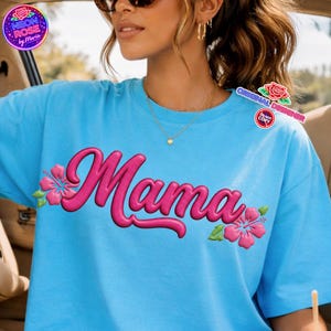 May include: A light blue t-shirt with the word "Mama" in pink, adorned with pink hibiscus flowers and green leaves. The shirt has short sleeves and a round neckline. The image also includes the text "Neon Rose by Maria" and "Original Designer".