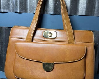Bolso de mano tipo satchel MCM de piel color coñac Meyers, estilo años 60, de la vieja aristocracia de Hollywood.