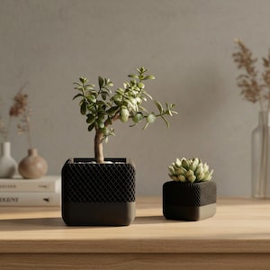 May include: A set of three ceramic mugs with a speckled, matte finish in cream, light grey, and dark grey. Each mug has a simple, minimalist design and a rounded handle.