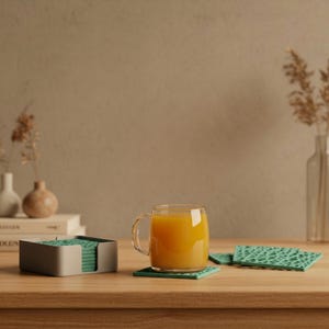 Könnte beinhalten: Eine weiße Keramik-Tasse mit schwarzem Henkel und dem Text "But First, Coffee" in schwarzer, fetter Schrift. Die Tasse steht auf einer weißen Oberfläche.