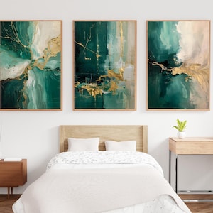 Peut inclure: Trois impressions d'art abstraites encadrées. Chacune présente un design unique avec des coups de pinceau turquoise, blancs et dorés. L'œuvre est exposée au-dessus d'un lit avec une tête de lit en bois, créant une esthétique de chambre moderne et artistique.