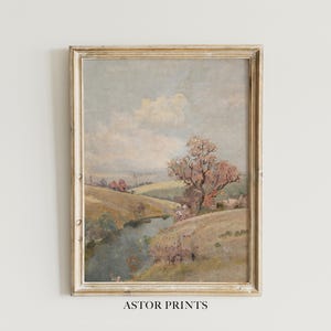 Könnte beinhalten: Gerahmtes Landschaftsgemälde mit einer ruhigen Flussszene. Das Kunstwerk zeigt sanfte Hügel, einen Baum mit rosa Blättern und einen bewölkten Himmel. Der Rahmen ist goldfarben. Der Text "ASTOR PRINTS" befindet sich unten.