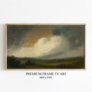 Könnte beinhalten: Gerahmtes Landschaftsgemälde mit dramatischem Himmel. Das Kunstwerk zeigt einen bewölkten Himmel mit Grautönen, Braun und Gelb über einer grünen und braunen Landschaft. Der Text "PREMIUM FRAME TV ART" befindet sich unten.