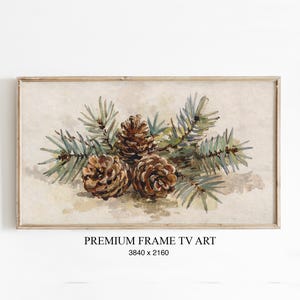 Könnte beinhalten: Gerahmtes Aquarellgemälde mit drei braunen Tannenzapfen und grünen und blau-grünen Tannenzweigen. Der Text "PREMIUM FRAME TV ART" befindet sich unten. Der Rahmen ist aus Holz.