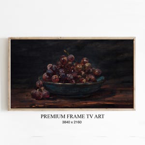Könnte beinhalten: Gerahmter digitaler Kunstdruck mit einem Stillleben von Trauben in einer blauen Schale. Die Trauben haben eine tiefviolette Farbe, und die Schale steht auf einer Holzoberfläche. Der Text "PREMIUM FRAME TV ART" befindet sich unten.