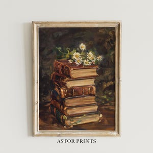 Könnte beinhalten: Gerahmter Kunstdruck im antiken Stil mit einem Stapel alter Bücher mit ledergebundenen Einbänden. Weiße Gänseblümchen liegen auf den Büchern. Der Druck hat einen dunklen Hintergrund und den Text "ASTOR PRINTS" am unteren Rand.