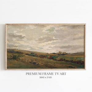 May include: A framed landscape painting with a muted color palette. The artwork depicts rolling green hills under a cloudy sky. The frame is a light wood color. Text at the bottom reads "PREMIUM FRAME TV ART" and the dimensions.