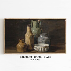 May include: A framed still life painting featuring a collection of antique pottery. The artwork showcases a variety of vessels in earthy tones, including a bottle, vases, and a bowl. The text "PREMIUM FRAME TV ART" is at the bottom.