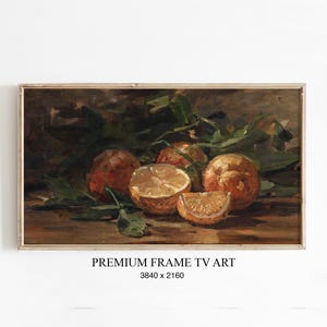 Könnte beinhalten: Gerahmtes Stillleben mit Orangen und grünen Blättern. Eine Orange ist halbiert, eine andere in einem Spalt geschnitten. Der Text "PREMIUM FRAME TV ART" befindet sich unten.