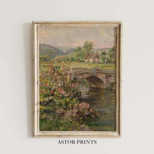Könnte beinhalten: Gerahmtes Landschaftsgemälde mit einer Steinbrücke über einem Fluss und einem Cottage im Hintergrund. Bunte Blumen säumen das Ufer. Das Gemälde hat einen goldfarbenen Rahmen. Der Text "ASTOR PRINTS" steht unten.