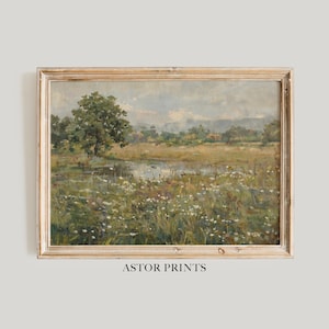 May include: A framed landscape painting depicting a field of wildflowers, a pond, and a tree. The artwork has a vintage aesthetic with a light brown wooden frame. The text "ASTOR PRINTS" is printed at the bottom of the frame.