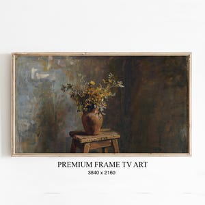 Könnte beinhalten: Gerahmter digitaler Kunstdruck mit einem Stillleben. Eine braune Vase mit gelben und grünen Blumen steht auf einem kleinen Holzschemel. Der Hintergrund hat ein dunkles, strukturiertes Aussehen. Der Text "PREMIUM FRAME TV ART" wird darunter angezeigt.