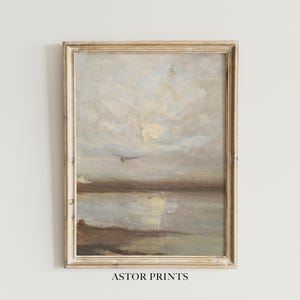 Könnte beinhalten: Gerahmtes Landschaftsgemälde mit gedämpften Farben. Das Kunstwerk zeigt einen bewölkten Himmel über Wasser und Land. Der Rahmen ist hellgoldfarben. Der Text "ASTOR PRINTS" befindet sich unten.