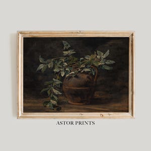 Könnte beinhalten: Gerahmter Vintage-Kunstdruck mit einer braunen Kanne, gefüllt mit grünen Zweigen. Das Kunstwerk hat eine dunkle, stimmungsvolle Ästhetik und einen Holzrahmen. Der Text "ASTOR PRINTS" ist unten aufgedruckt.
