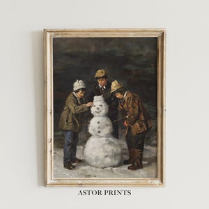 May include: Framed vintage print depicting three children building a snowman in a snowy landscape. The children are wearing winter coats and hats. The print has a warm, antique aesthetic, with the text "ASTOR PRINTS" at the bottom.