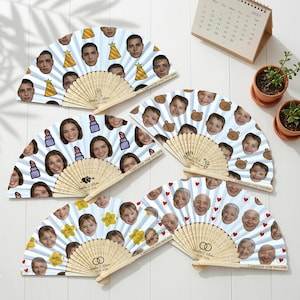 May include: A collection of personalized hand fans with various designs. Each fan features a different pattern, including faces, lipstick, teddy bears, stars, and hearts. The fans have wooden handles and include the text "Customize your text date".