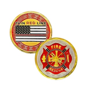 Puede incluir: Dos monedas doradas. Una moneda presenta la bandera estadounidense con una línea roja y el texto "THIN RED LINE". La otra moneda tiene un emblema rojo de los bomberos con las palabras "FIRE RESCUE".