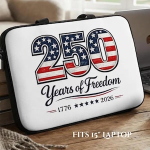 May include: A white laptop sleeve with black trim featuring the text 250 Years of Freedom, 1776-2026, and five stars. The number 250 is filled with a red, white, and blue American flag pattern. The sleeve is designed to fit a 15-inch laptop.