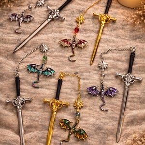 May include: A selection of fantasy-themed sword bookmarks with dragon pendants. The bookmarks have silver and gold finishes, black handles, and dragon wings in red, green, blue, and purple. Decorative and detailed, ideal for book enthusiasts.