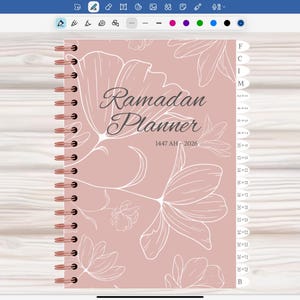 May include: A spiral-bound Ramadan Planner with a soft pink cover featuring floral line art and the words "Ramadan Planner" in elegant script. The planner includes the dates 1447 AH - 2026 and has tabbed sections for organization.