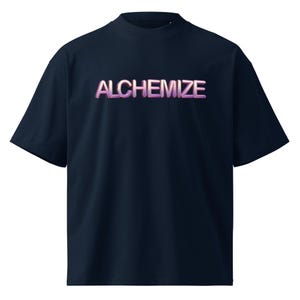 May include: Navy blue t-shirt with the word "ALCHEMIZE" in a gradient pink and purple font. The shirt has a mock neck and short sleeves. The t-shirt is made of a soft material.