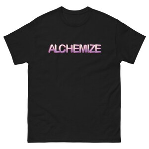 May include: Black t-shirt with the word "ALCHEMIZE" in a gradient purple and white font across the chest. The t-shirt has short sleeves and a crew neck.
