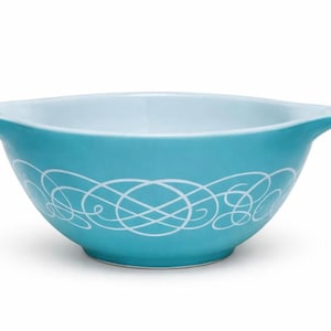 May include: A turquoise ceramic mixing bowl with a white interior and a decorative white swirl pattern around the exterior. The bowl has two handles and is suitable for kitchen use.