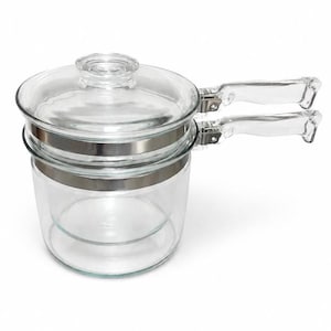 May include: A clear glass double boiler set consisting of a bottom pot and a top insert, both featuring silver-toned metal bands. The set includes a matching clear glass lid with a knob handle and two clear glass side handles attached to the metal bands.