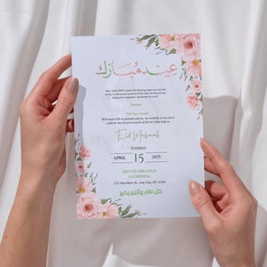 Puede incluir: Una tarjeta de invitaci&oacute;n blanca con detalles florales y escritura &aacute;rabe, sostenida por manos. La tarjeta dice "Eid Mubarak" e incluye detalles para una celebraci&oacute;n de Eid el 15 de abril de 2025, con una direcci&oacute;n.