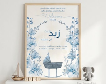 Puede incluir: Un cuadro rectangular con marco de madera clara que presenta ilustraciones florales en acuarela azul, un gráfico de cuna mecedora azul y texto en árabe. Incluye el texto en inglés Welcome baby y el nombre Zade en letra azul.
